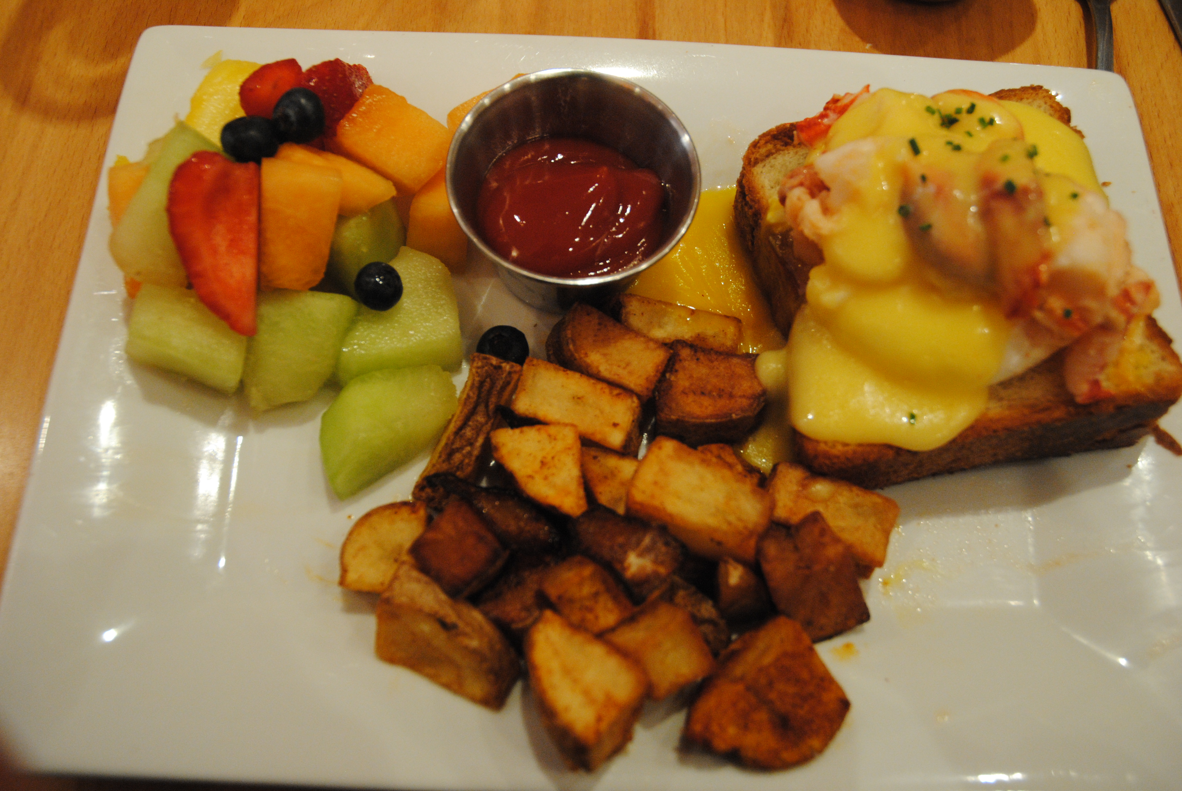 Eggs Benedict w/ home fries and fruit, on amazing bread - Click to see more of the Menu at Claw